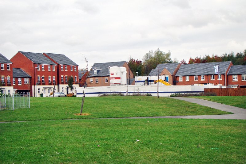 574-A view of the.jpg - 574-A view of the Bellway builders yard from across the Village Green from West Street.